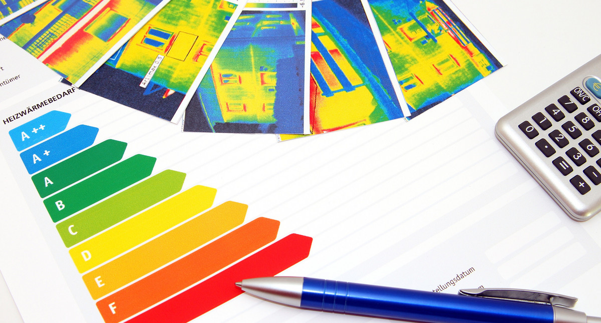 Ansprechpartner Energieberatung Blick auf den Tisch eines Energieberaters: Wärmebilder, Taschenrechner und Verbauchstabelle