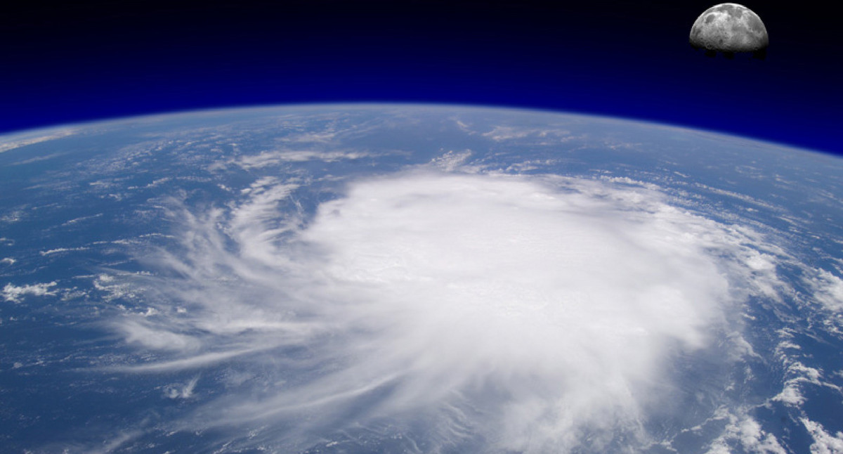 Blick vom Weltall auf einen riesigen Hurrikan über dem Meer mit Mond im Hintergrund